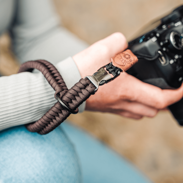 Zu sehen ist die Kamera Handschlaufe von C-Rope Kamerazubehör in der Farbe Dark Coffee mit dem Schnellverschlusssystem, welches sich an Kameragurten und Handschlaufen befindet