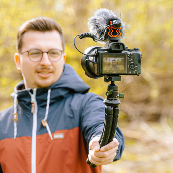 Zu sehen ist eine Person, die mithilfe des Creatorpod Stativ ein Selfie mit der Kamera macht.