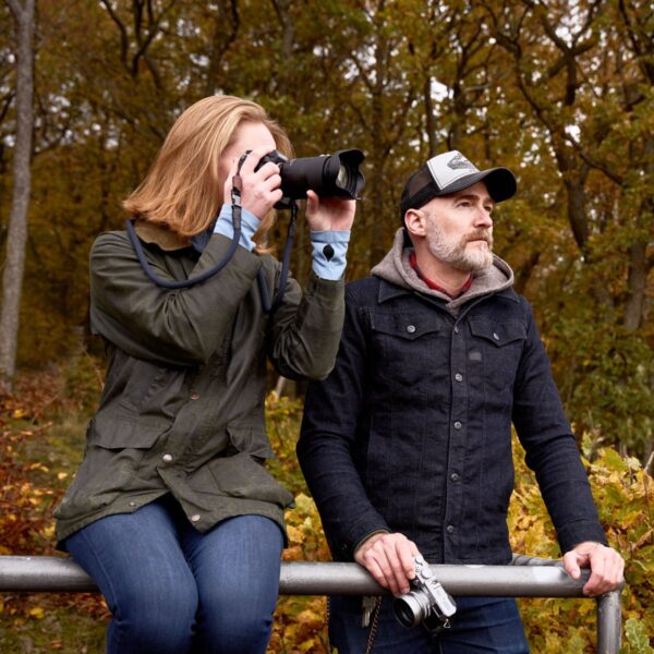 Frau trägt Kameragurt aus Kletterseil in der Natur neben einem Mannin der Farbe navy blue.
