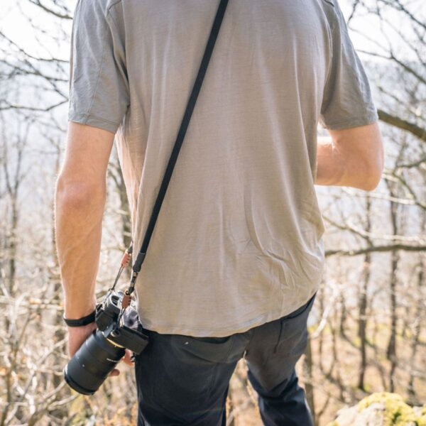 Mann trägt Kameragurt aus Kletterseil in der Natur in der Farbe silent black.