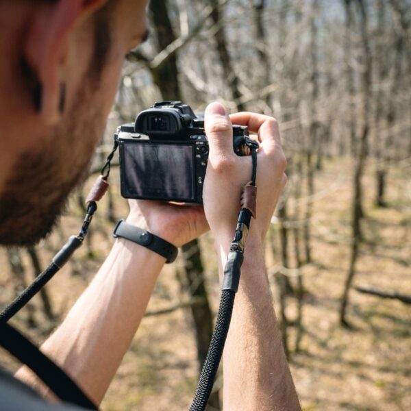 Mann trägt Kameragurt aus Kletterseil in der Natur in der Farbe silent black.