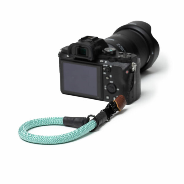 Hier sieht man eine Kamera mit der C-Rope Kamera Handschlaufe in der Farbe Mighty Mint.