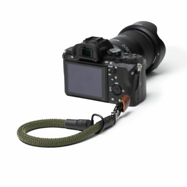 Hier sieht man eine Kamera mit der C-Rope Kamera Handschlaufe in der Farbe Military Olive.