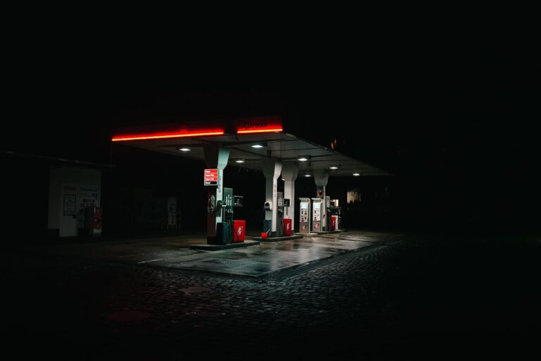 Abgebildet ist eine beleuchtete Tankstelle bei Nacht.