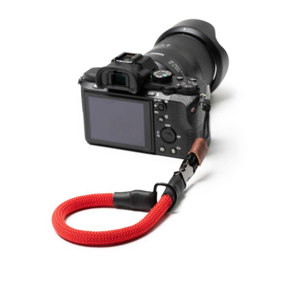 Kamerahandschlaufe aus Kletterseil vor weißem Hintergrund in der Farbe bright red.